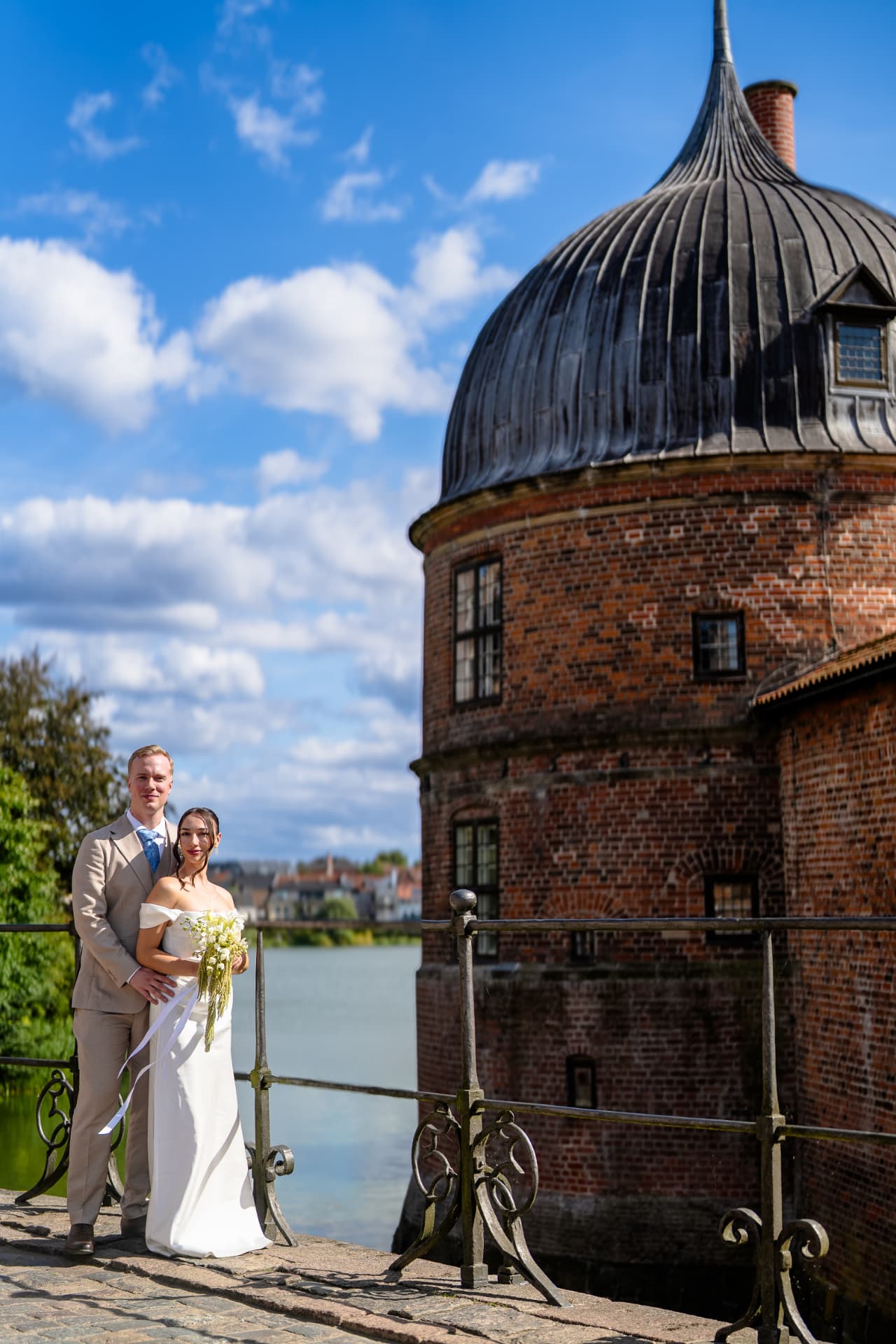 Bride and groom by the moat tower at Frederiksborg Slot, castle wedding photographer Hillerod Denmark