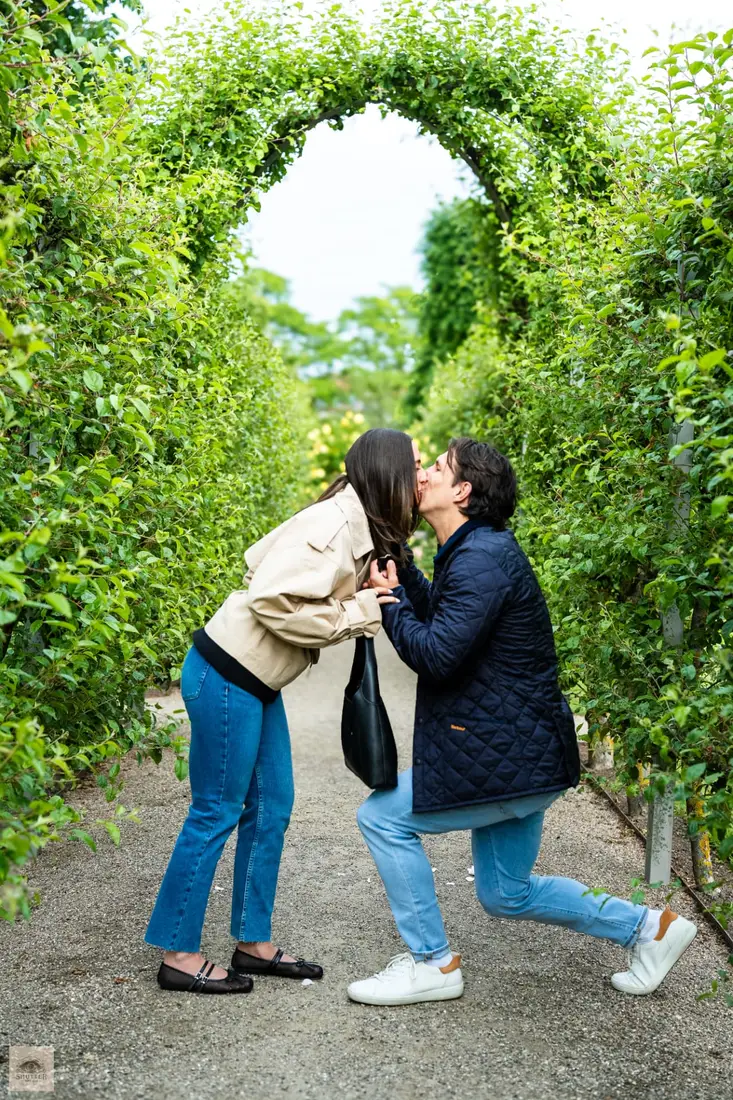 Couple kissing right after the proposal under the garden archway, Copenhagen proposal photographer